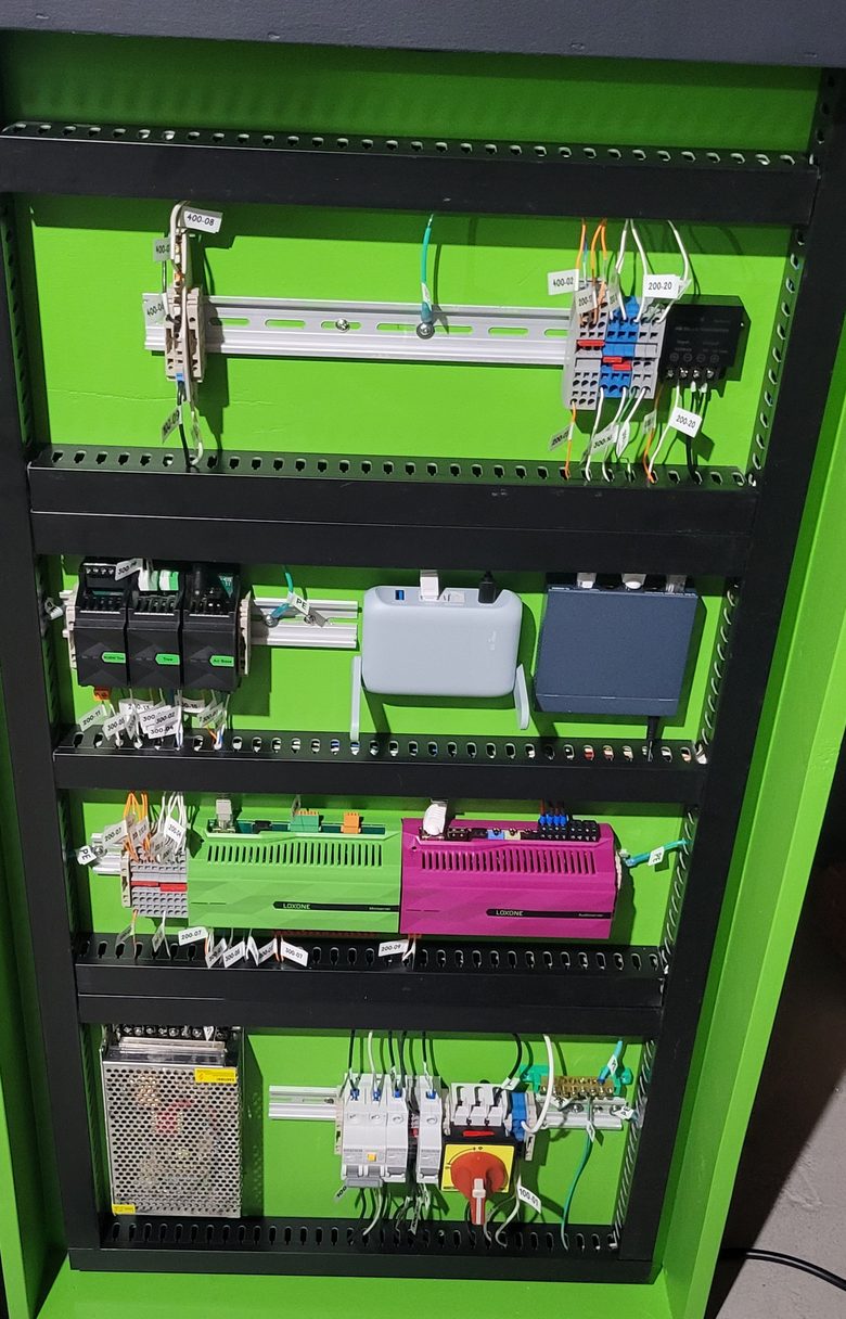 Cornerstone control panel interior: Loxone Miniserver and Audioserver on DIN rail, labelled conductors, breakers and power supply.